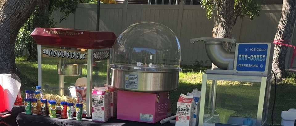 Popcorn, cotton candy and sno-cone machines set up together on one concession table