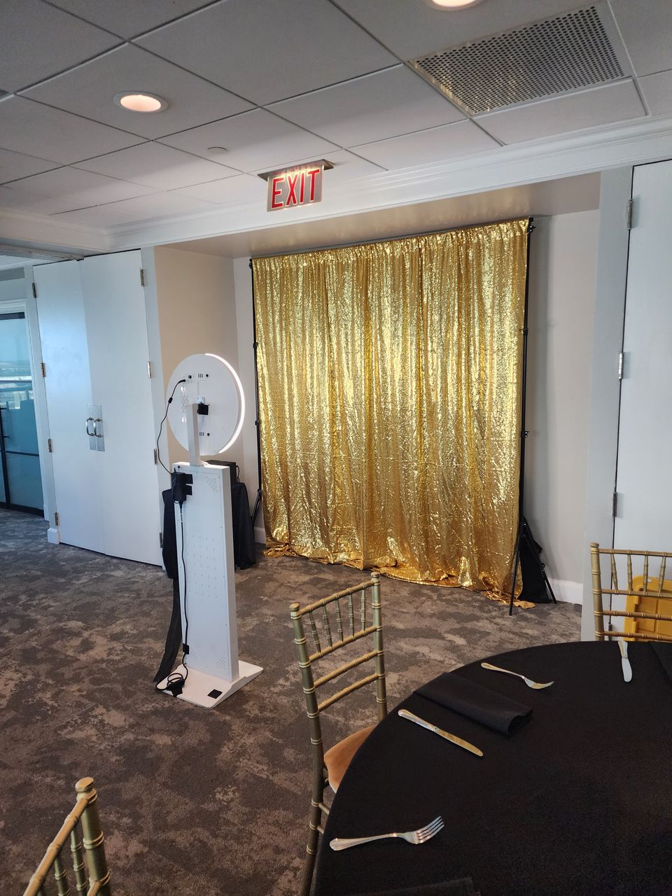 White selfie station with gold sequin backdrop at a May 2025 event