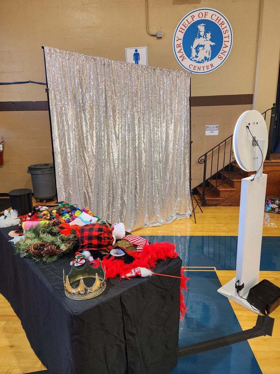 Selfie station with silver sequin backdrop at a holiday-decorated event