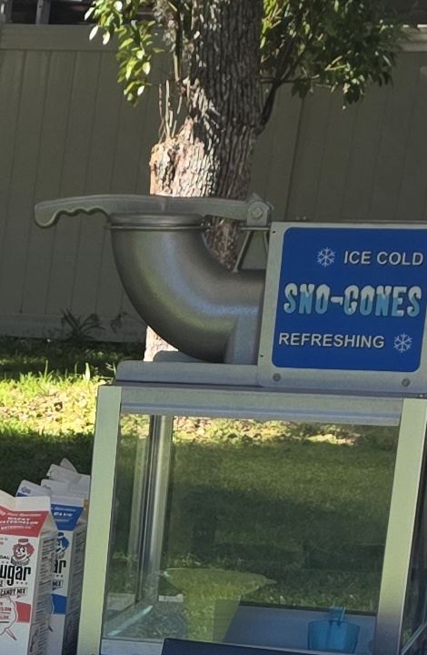 Sno-cone machine with ICE COLD SNO-CONES sign and supplies